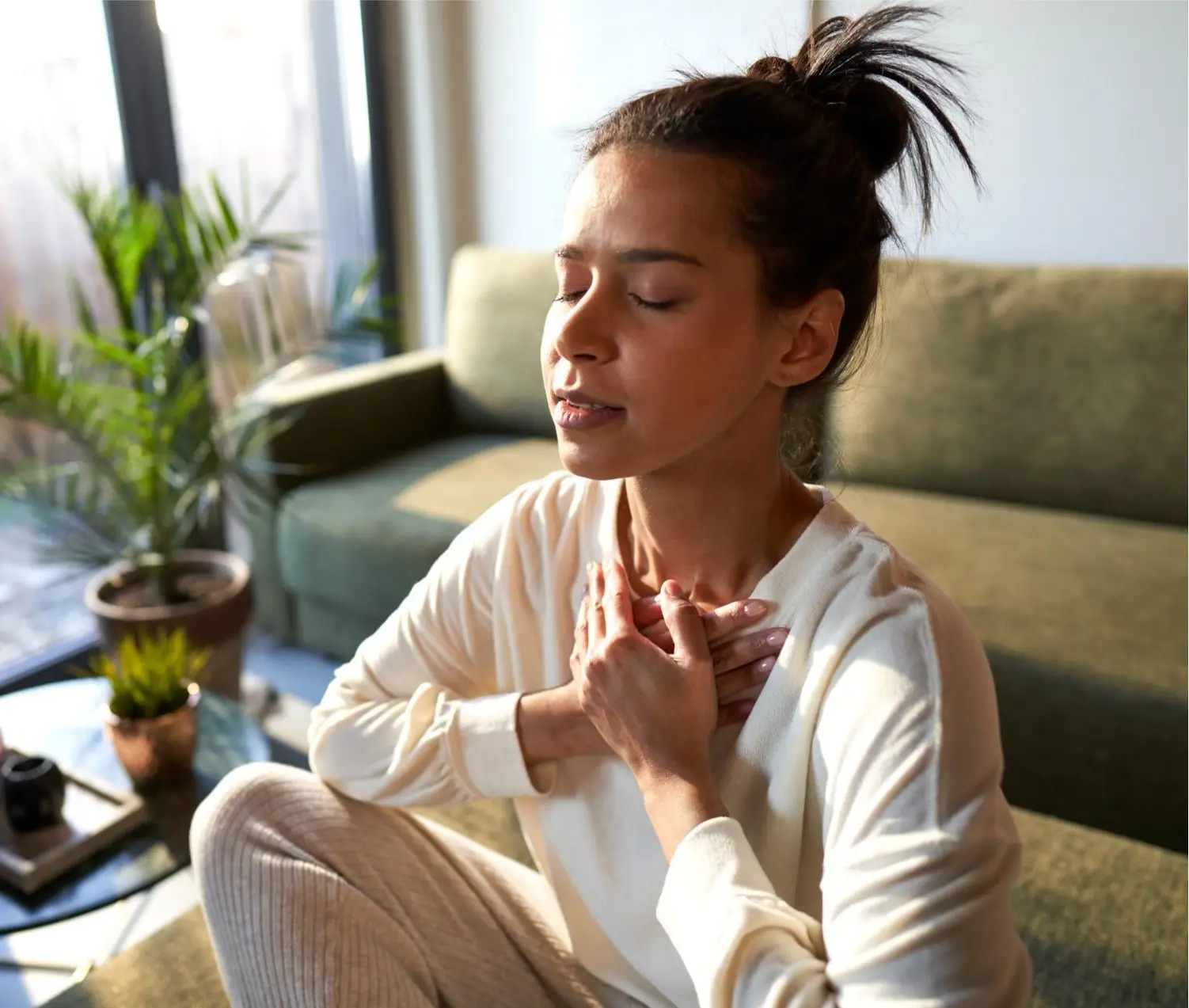 Mixed race woman meditating at home with eyes closed