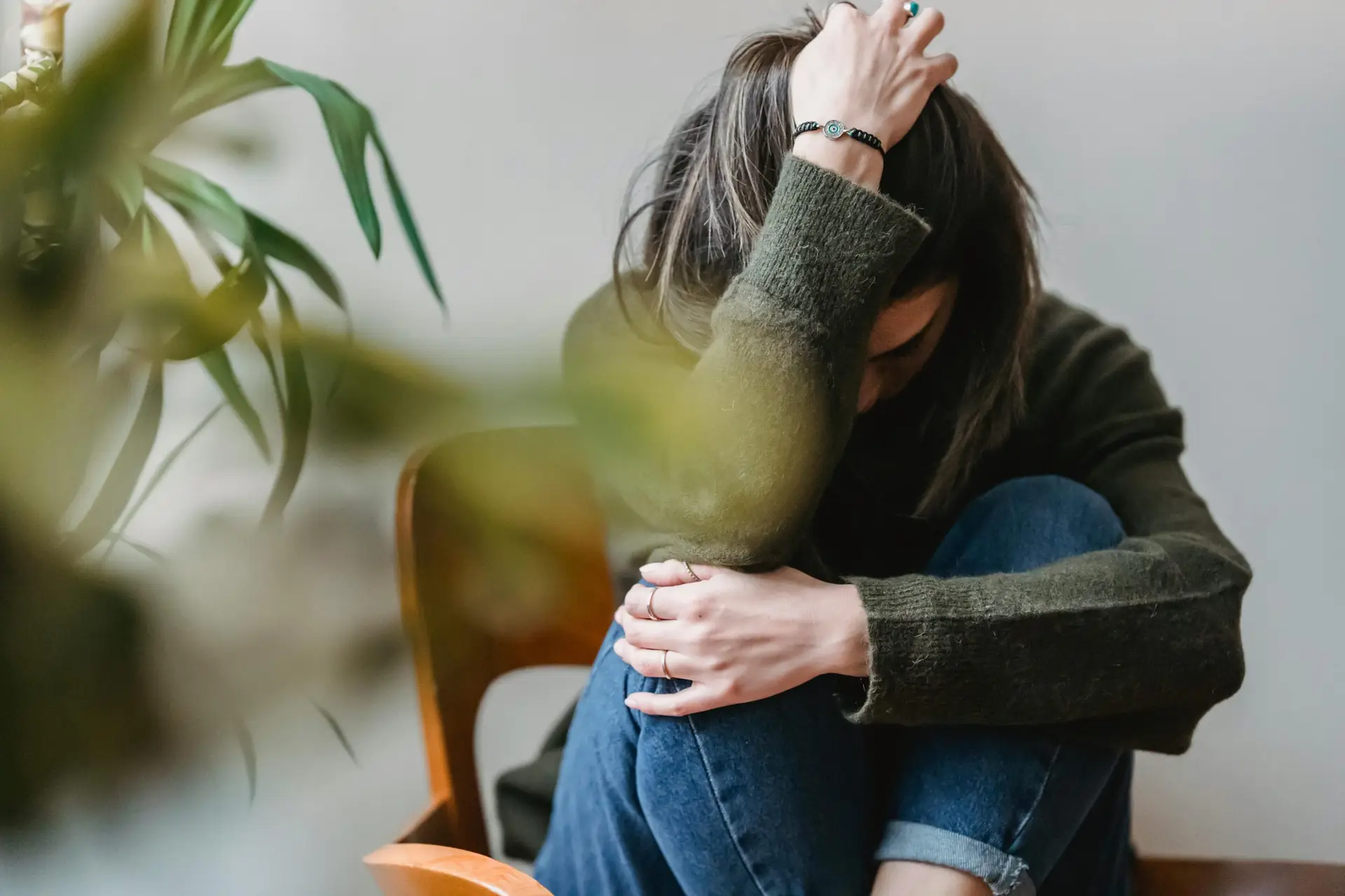 Woman grabbing her head with one hand overwhelmed with anxiety.