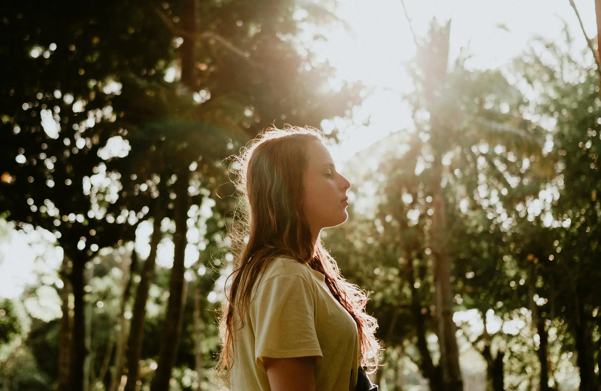 woman using somatic therapy breathing techniques in nature