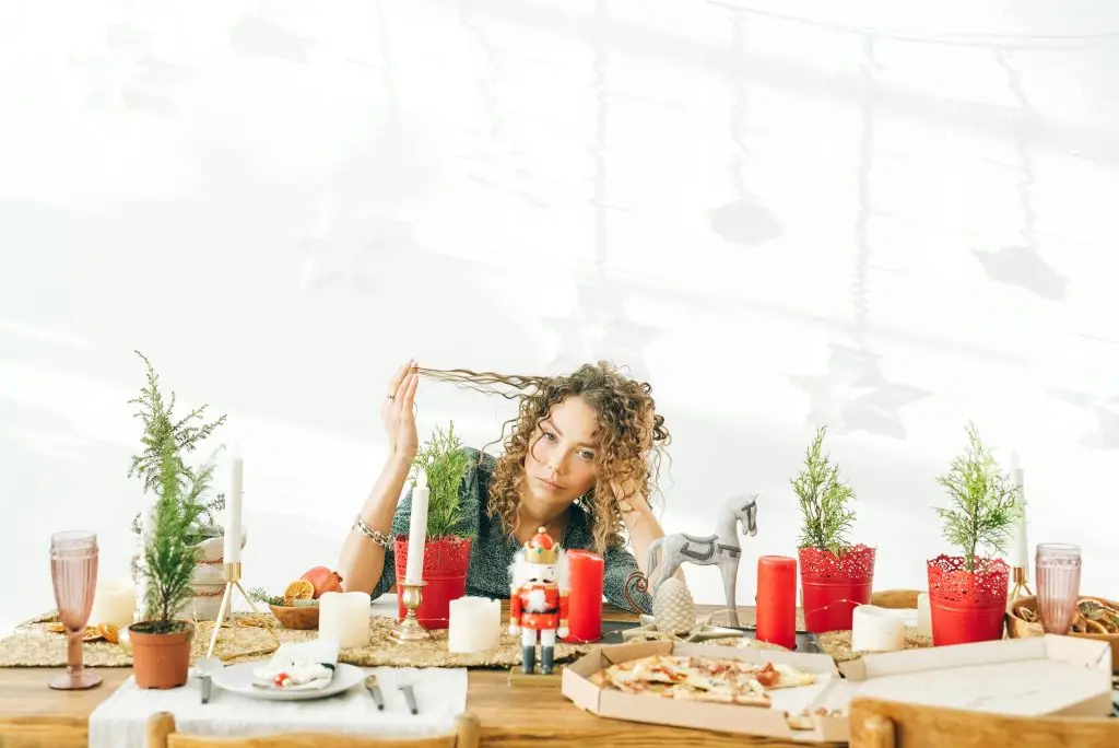 woman seating at the dinner table feeling holiday anxiety