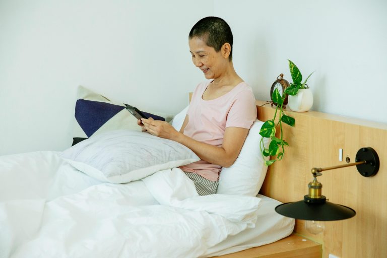 person looking at phone in bed
