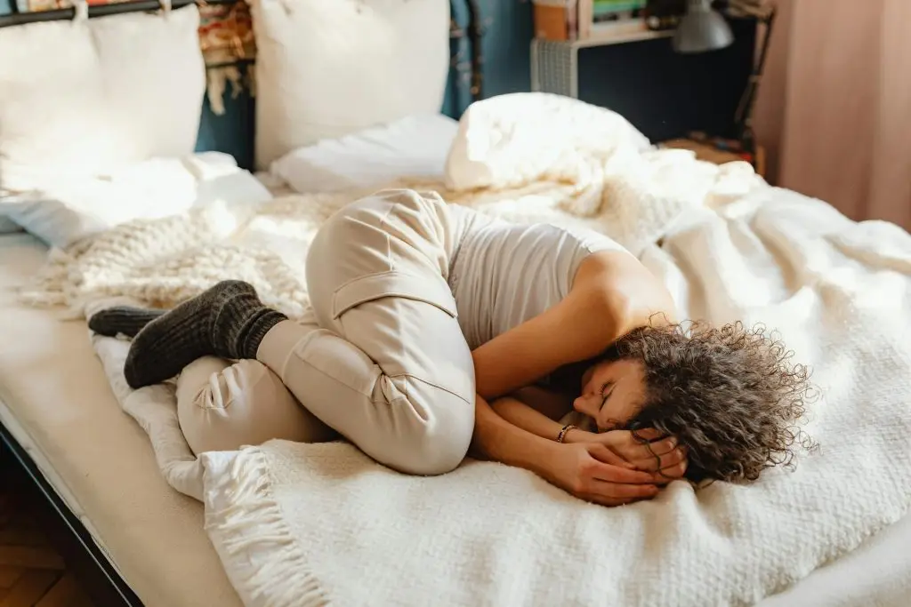 woman lying on the bed in pain